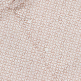 A close-up of the ISAIA Superlino Print Dress Shirt, a beige and white men's shirt with a geometric grid pattern, white buttons, and a red “ISAIA” label on the collar.