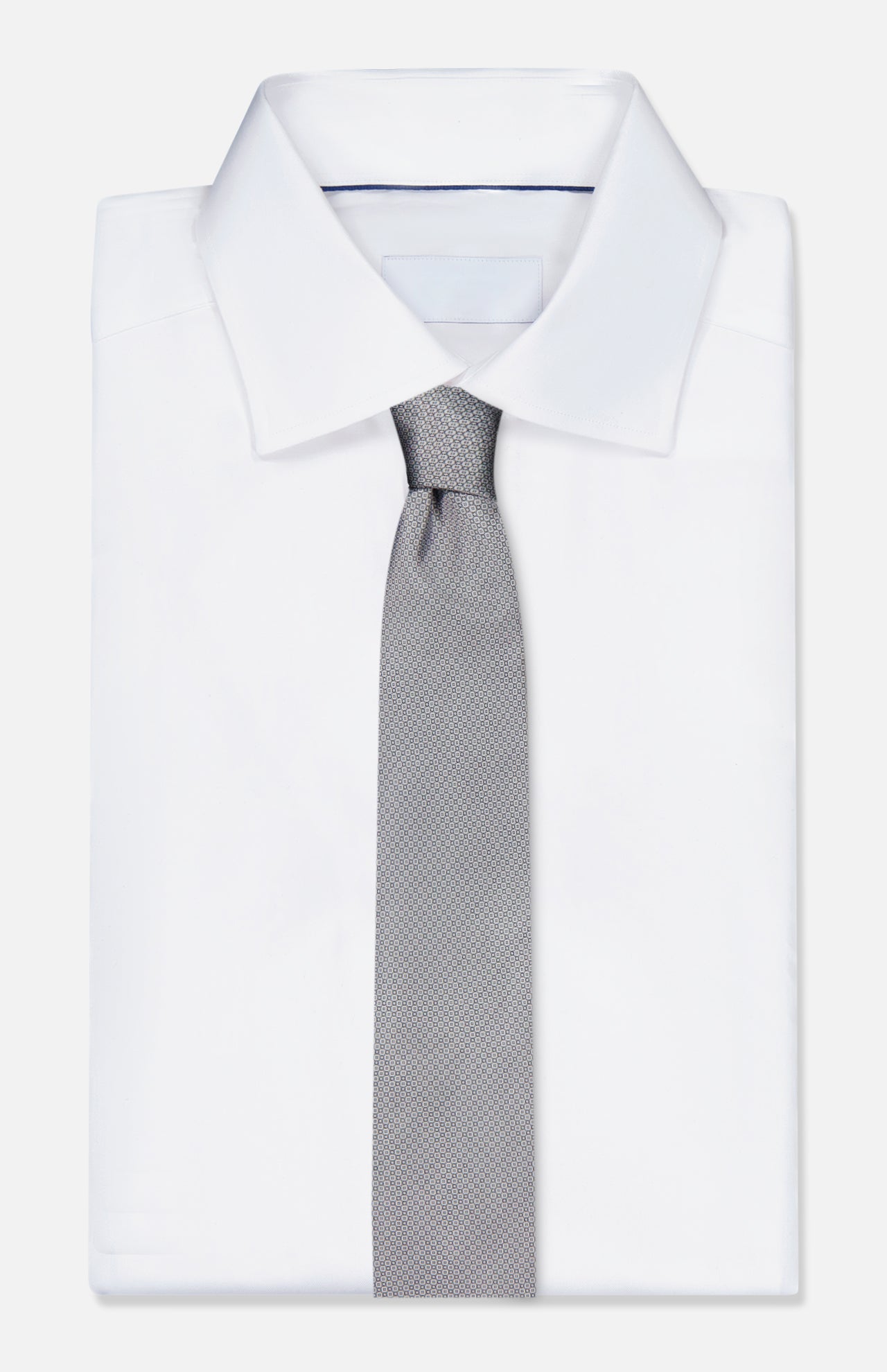 A neatly folded white dress shirt with an ITALO FERRETTI Geometric Pattern Neck Tie, light gray and textured, displayed on a plain white background.