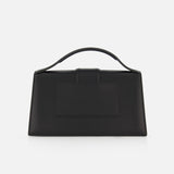 The JACQUEMUS Le Grand Bambino Bag is a minimalist black leather rectangular top-handle bag made in Italy, shown against a plain white background.