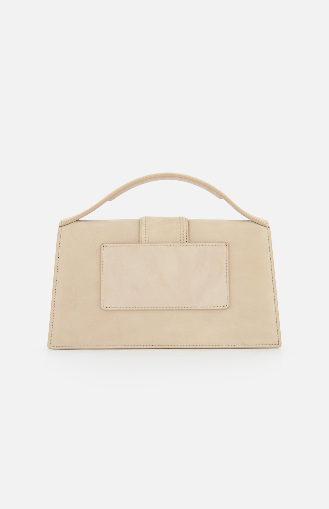 The Le Grand Bambino Bag by JACQUEMUS is a rectangular beige suede tan leather top-handle bag with a large front pocket and short handle, shown against a plain white background.