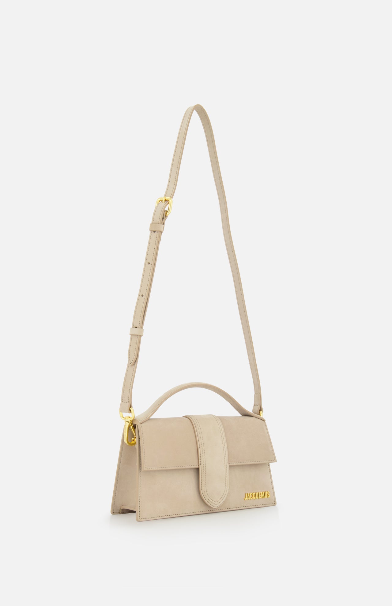 The JACQUEMUS Le Grand Bambino Bag is a tan leather top-handle bag with gold accents, crafted in Italy and featuring an adjustable crossbody strap for versatile styling.