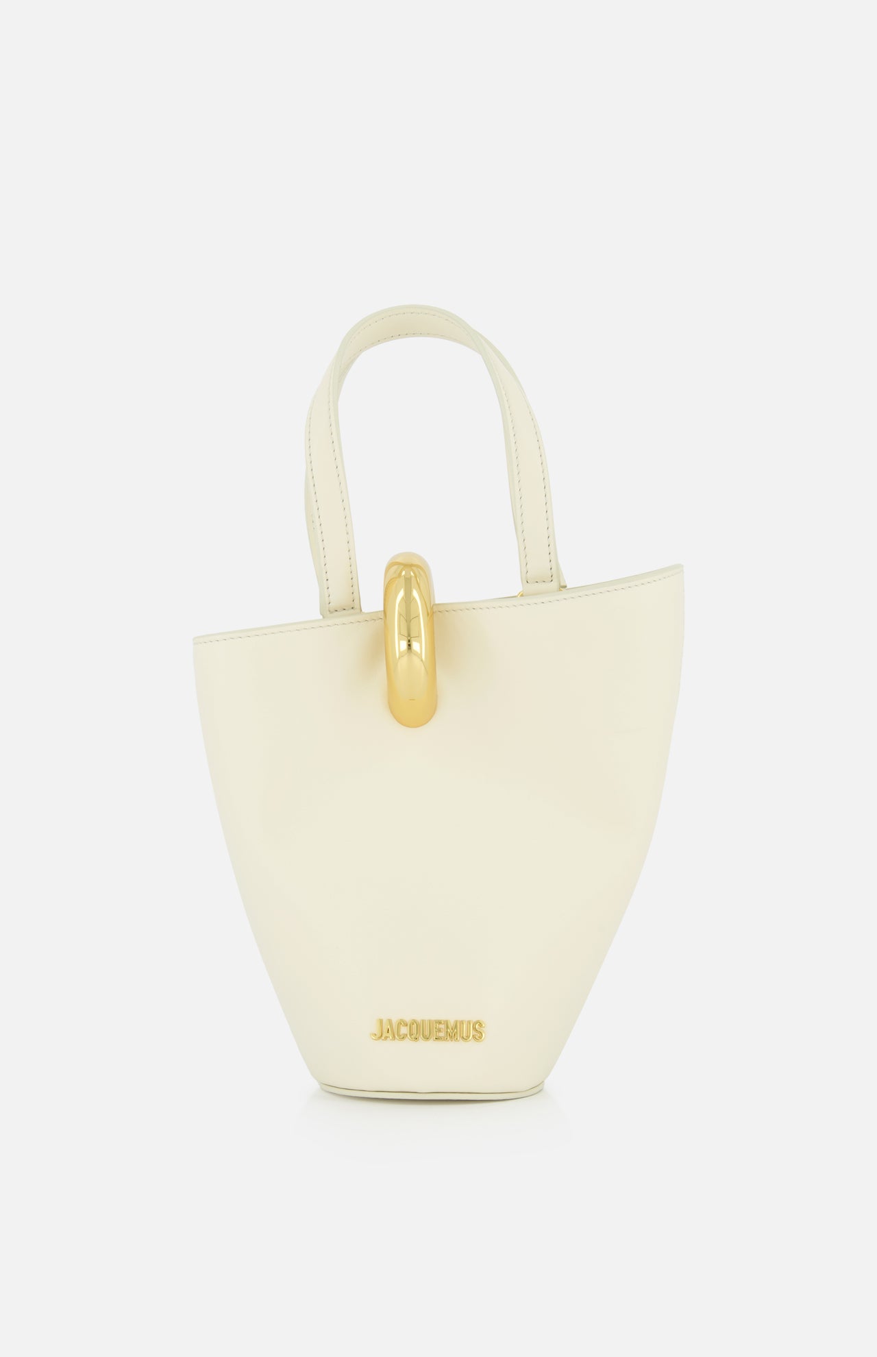 The Le Petit Bambola Tote Bag by JACQUEMUS is a small, structured off-white handbag with dual handles, gold hardware, and “JACQUEMUS” in gold lettering on the front for a minimalist, elegant look.
