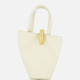 The JACQUEMUS Le Petit Bambola Tote Bag, crafted in cream leather with two handles and a gold front clasp, is displayed against a plain white background.