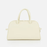The Le Petit Turismo Bowling Bag by JACQUEMUS is a cream-colored, structured leather accessory with two rounded handles and a minimalist design, exuding quiet luxury against a plain white background.