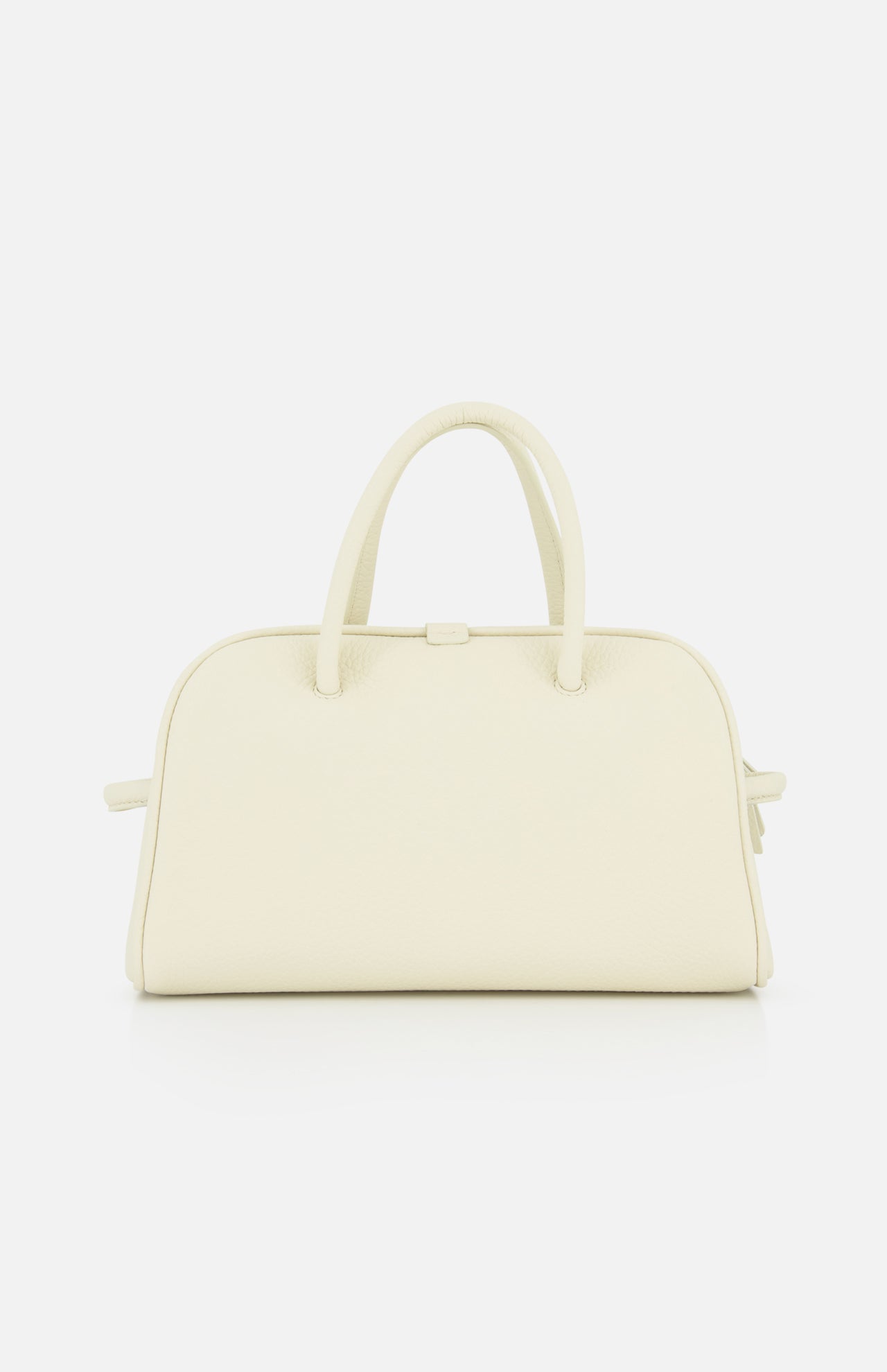 The Le Petit Turismo Bowling Bag by JACQUEMUS is a cream-colored, structured leather accessory with two rounded handles and a minimalist design, exuding quiet luxury against a plain white background.