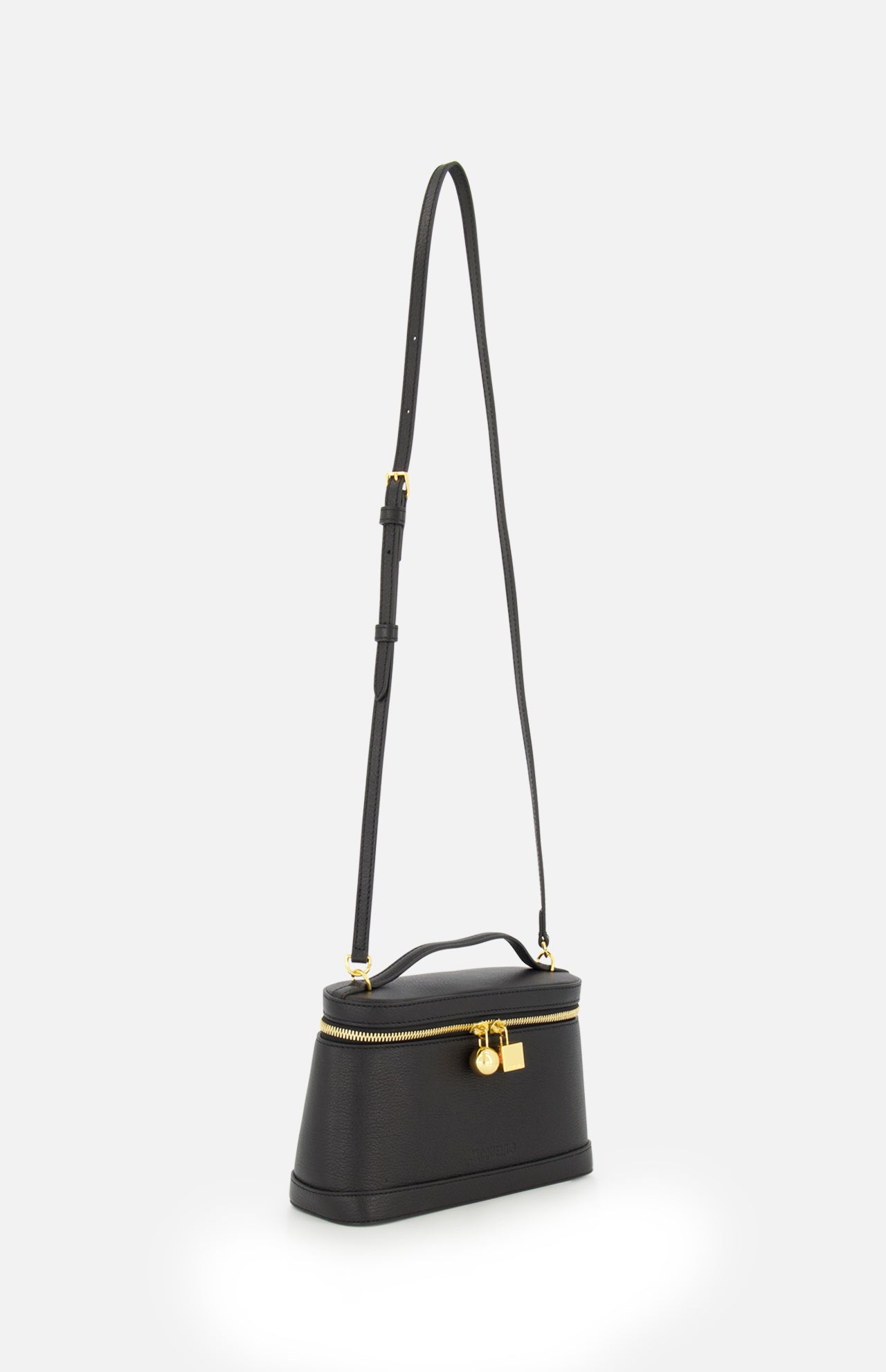 The Le Petit Vanity Bag by JACQUEMUS is a vintage-inspired crossbody crafted from black leather, featuring a sleek top handle, gold zipper, and an elegant gold padlock detail, shown against a plain white background.