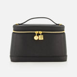 The Le Petit Vanity Bag by JACQUEMUS is a black leather bag with a structured silhouette, featuring a top handle, gold zipper, and gold lock details reminiscent of a vintage vanity case. It is displayed against a plain white background.