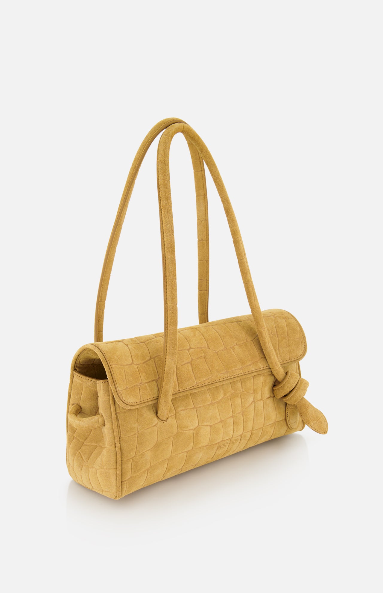 The Le Turismo Long Shoulder Bag by JACQUEMUS is a medium-sized, mustard yellow suede handbag featuring a textured grid-like pattern, long rounded handles, and a distinctive knotted detail on one side. Expertly crafted in Italy, this elegant accessory is showcased against a plain white background.