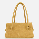 The Le Turismo Long Shoulder Bag by JACQUEMUS is a medium-sized, mustard yellow rectangular handbag with a crocodile-textured finish, featuring two long handles and crafted in Italy, set against a plain white background.