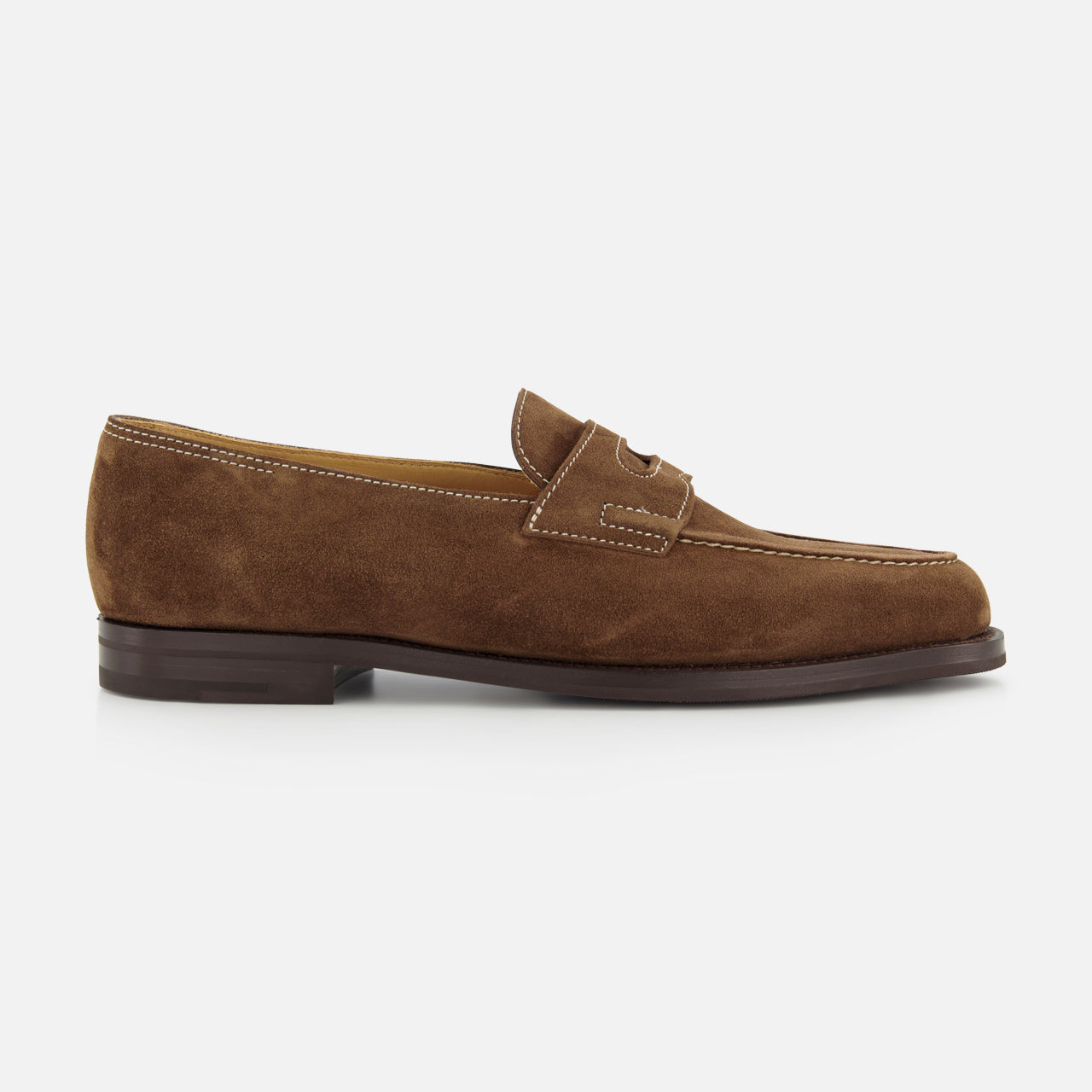 The JOHN LOBB Lopez Suede Loafer is a handmade dark brown suede shoe with white stitching, a low matching heel, and classic penny slot detail, crafted in England and shown on a plain white background for timeless style.