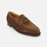 The JOHN LOBB Lopez Suede Loafer is a classic dark brown suede loafer, handmade in England with white stitching, a rounded toe, low heel, and decorative cutout on the upper, shown against a plain white background.
