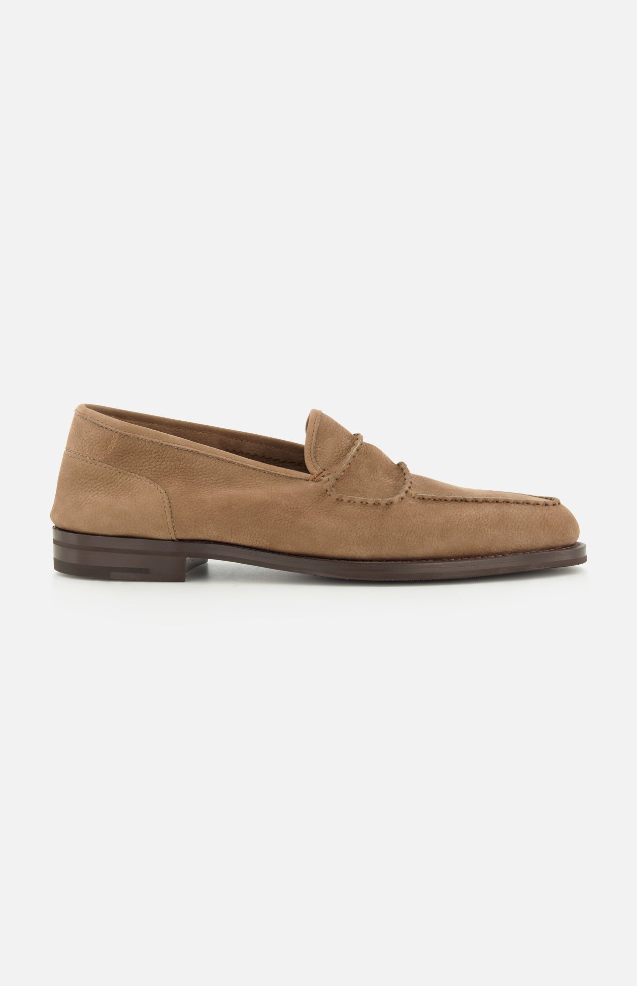 The Bath Nubuck Loafer by JOHN LOBB features a tan nubuck finish, low heel, visible stitching details, and a moc toe design—its refined silhouette takes cues from classic handmade men’s loafers. Displayed here in side profile against a white background.