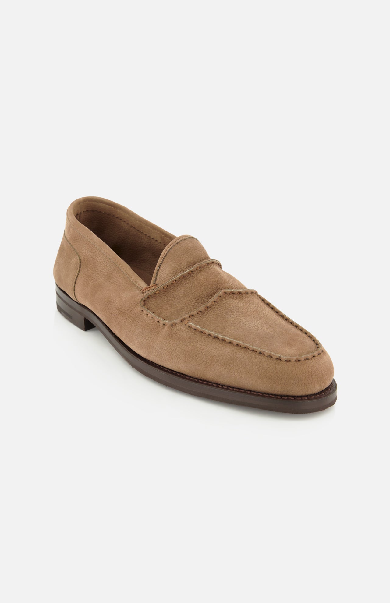 The Bath Nubuck Loafer by JOHN LOBB is a tan slip-on shoe featuring a moccasin toe, visible stitching, and a low dark brown sole. Displayed on a white background, this unlined loafer is inspired by classic handmade men’s styles and delivers effortless comfort and sophistication for everyday wear.