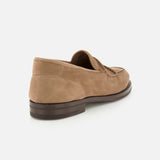 The Bath Nubuck Loafer by JOHN LOBB is showcased from the back and side on a plain white background, highlighting its tan nubuck upper, dark brown sole, and visible stitching. These handmade men’s loafers offer an unlined slip-on design focused on comfort and effortless style.
