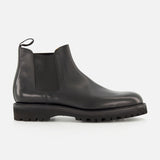 The Lawry Calfskin Boot by JOHN LOBB is a black leather Chelsea boot featuring a chunky treaded sole, elastic side panel, and rear pull tab in a slip-on style, displayed against a plain white background.