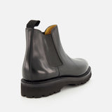 The Lawry Calfskin Boot by JOHN LOBB is a black leather Chelsea boot featuring a chunky sole, elastic side panel, and back pull tab, crafted in a classic slip-on style and displayed against a plain white background.