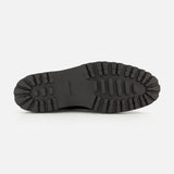 The image displays the bottom view of the JOHN LOBB Lawry Calfskin Boot, featuring a black leather sole with deep, rugged treads designed for enhanced grip and durability, showcasing classic English craftsmanship.