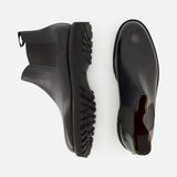 Two Lawry Calfskin Boots by JOHN LOBB in black are displayed on a white background—one viewed from the side and the other from above—highlighting their classic slip-on Chelsea style with elastic side panels and chunky textured soles.