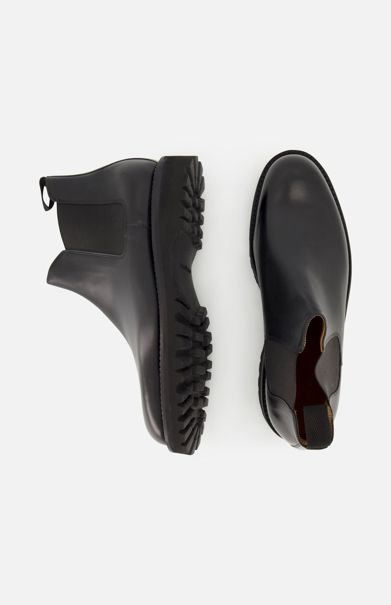 Two Lawry Calfskin Boots by JOHN LOBB in black are displayed on a white background—one viewed from the side and the other from above—highlighting their classic slip-on Chelsea style with elastic side panels and chunky textured soles.
