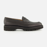 The Lopez Gentle Grain Loafer by JOHN LOBB is displayed in a side profile view against a plain white background, showcasing the expert craftsmanship of these handmade dark brown leather shoes with a chunky, ridged black sole, made in England.