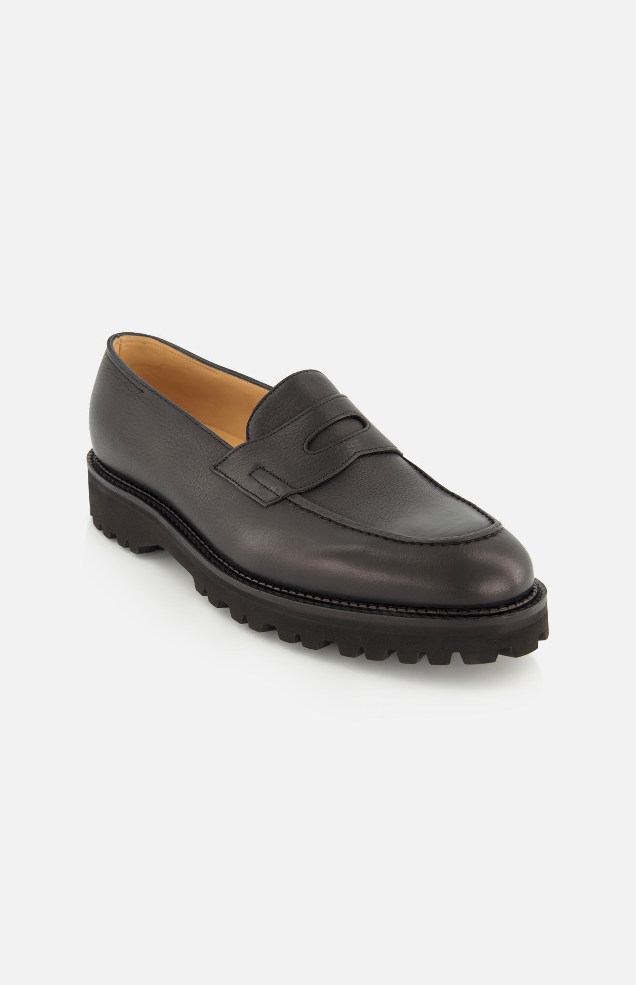 The Lopez Gentle Grain Loafer by JOHN LOBB is expertly crafted in England from black leather, featuring a chunky textured sole, visible stitching, and a classic penny slot detail on the upper—shown against a plain white background.