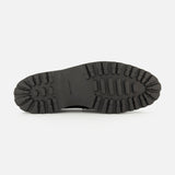 The image displays the black rubber sole of the JOHN LOBB Lopez Gentle Grain Loafer, featuring deep, chunky treads designed for superior grip and traction. Shown from the bottom, the entire length and intricate tread pattern are visible—an ideal foundation for this classic black leather loafer expertly handmade in England.