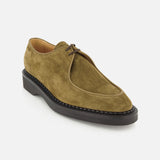 The Smith Suede Loafer by JOHN LOBB is an olive green suede lace-up shoe featuring a rounded toe, visible stitching around the sole, and a black rubber sole, drawing inspiration from classic English creepers. Made in England and shown on a plain white background.