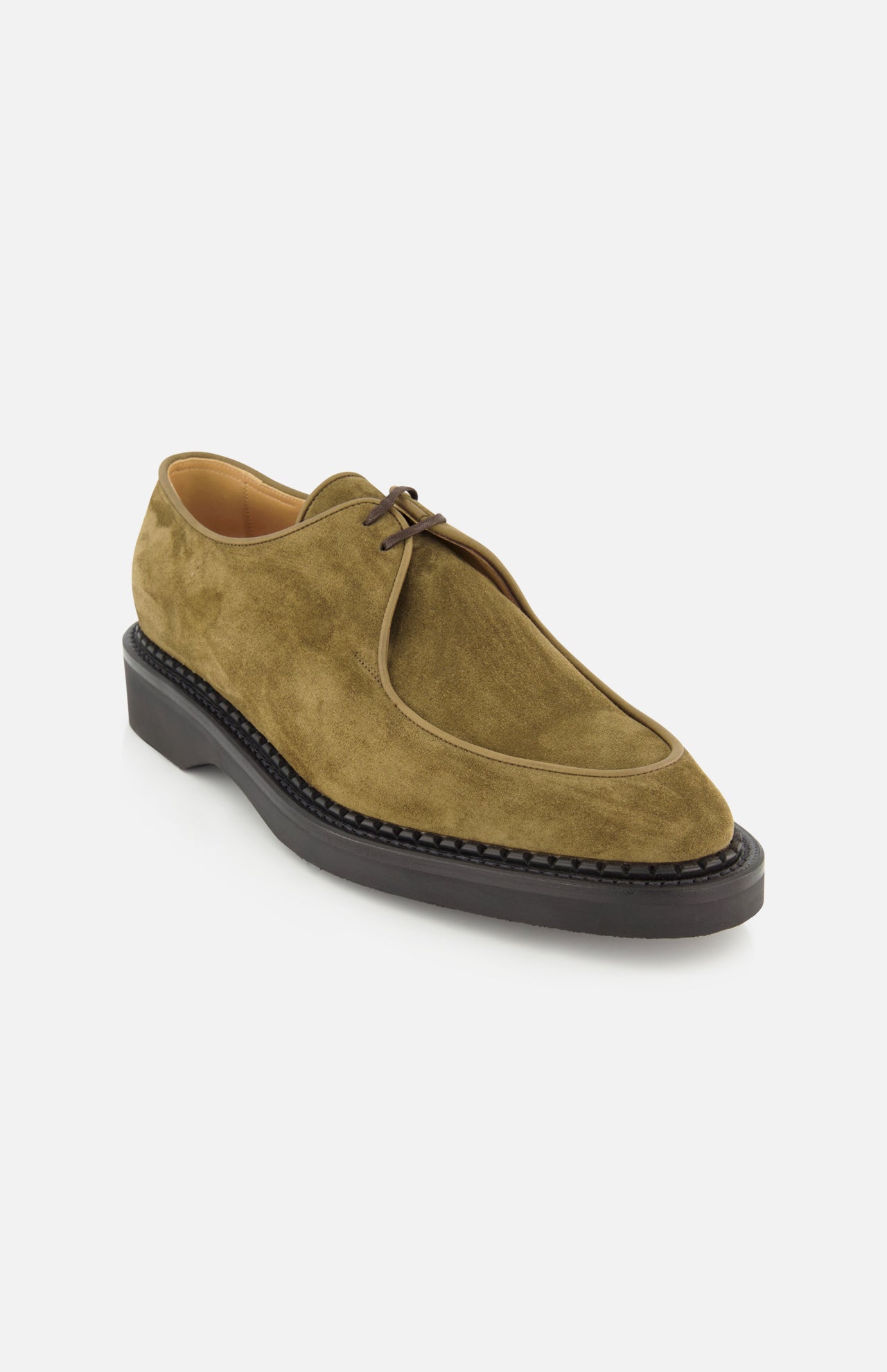 The Smith Suede Loafer by JOHN LOBB is an olive green suede lace-up shoe featuring a rounded toe, visible stitching around the sole, and a black rubber sole, drawing inspiration from classic English creepers. Made in England and shown on a plain white background.