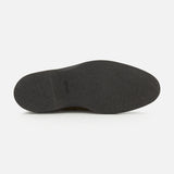 The image features the bottom view of the Smith Suede Loafer by JOHN LOBB—a single black shoe sole with a smooth, textured surface, photographed against a plain white background. This distinctive detail is characteristic of premium loafers made in England.