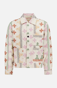 The KARDO Bodhi Shirt Jacket is a long-sleeve, collared jacket made in India from 100% cotton. It features a front pocket, quilted texture, and multicolored floral and geometric patchwork on a white background.
