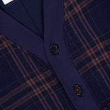 Close-up of the Janesh Quilted Plaid Cardigan by KARDO, featuring a dark blue and brown plaid pattern, black buttons, ribbed navy trim, and an interior white label with “KARDO M” and additional script. This men’s cardigan offers classic style blended with everyday comfort.