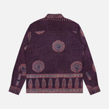 The Martin Relaxed Fit Long Sleeve Shirt by KARDO is a printed, relaxed-fit button-up featuring a purple base decorated with intricate circular and geometric patterns in shades of red, blue, and pink. Shown flat with the back facing up, this shirt seamlessly blends comfort with standout style.