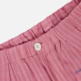 Close-up of the waistband of KARDO's Taka Striped Trouser Pants, showing relaxed fit in pink with vertical white stripes, a white button, elastic waistband, and lightweight textured fabric.