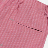 Close-up of KARDO's Taka Striped Trouser Pants—women's relaxed fit in pink with thin white vertical stripes, an elastic waistband, and a single welt back pocket.