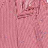 The Taka Striped Trouser Pants by KARDO feature a relaxed fit in soft embroidered cotton with thin white stripes, scattered colorful stitches, an elastic back waistband, partially open zip fly, and a cream button.