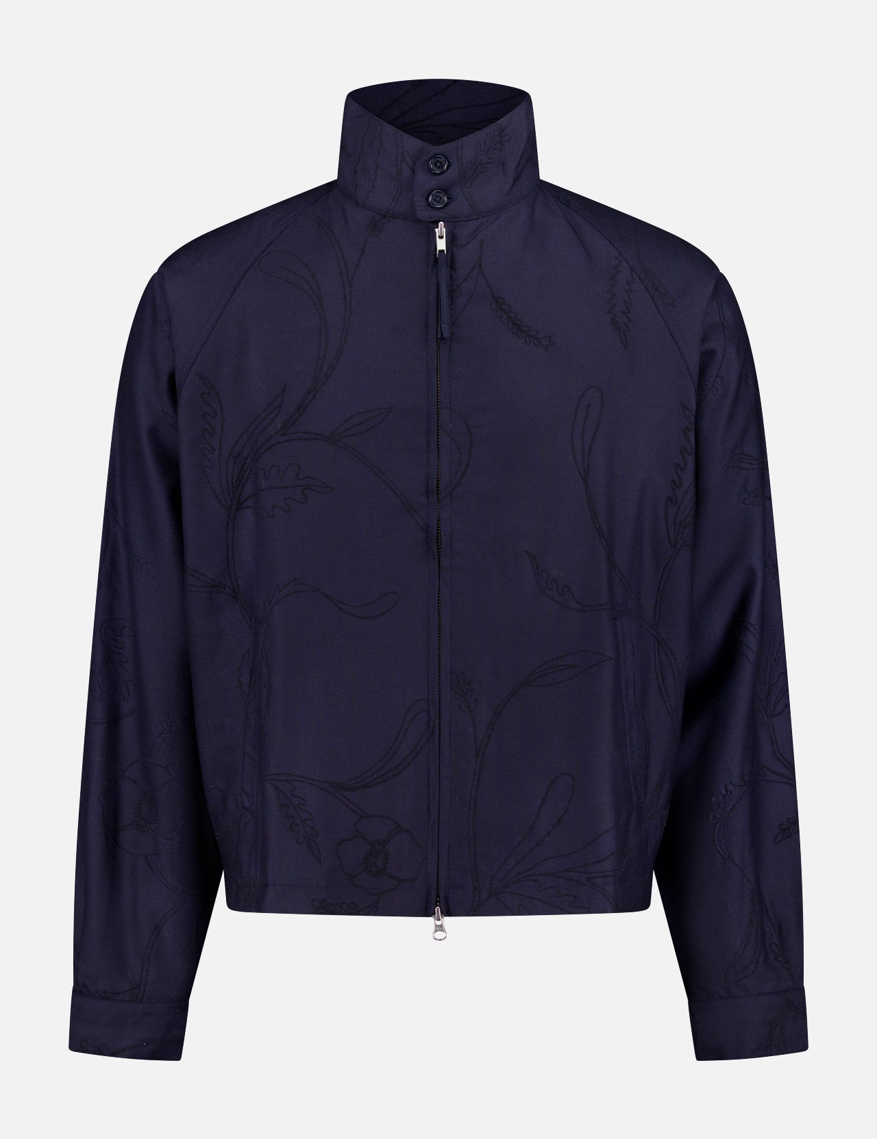The Stanley Full Zip Jacket by KARDO is a navy wool piece featuring a subtle floral pattern, high collar, front zipper, and long sleeves. Its boxy, slightly cropped fit offers a minimalistic, modern twist on mid-century menswear.