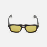 Alexander McQueen Pilot Brown Sunglasses by ALEXANDER MCQUEEN with dark brown frames and yellow-tinted lenses, shown on a white background.