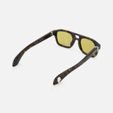 The Alexander McQueen Pilot Brown Sunglasses by ALEXANDER MCQUEEN are shown from a rear angle on a white background, featuring dark tortoiseshell frames, yellow-tinted lenses, open arms with metal hinges, and classic pilot style detailing.