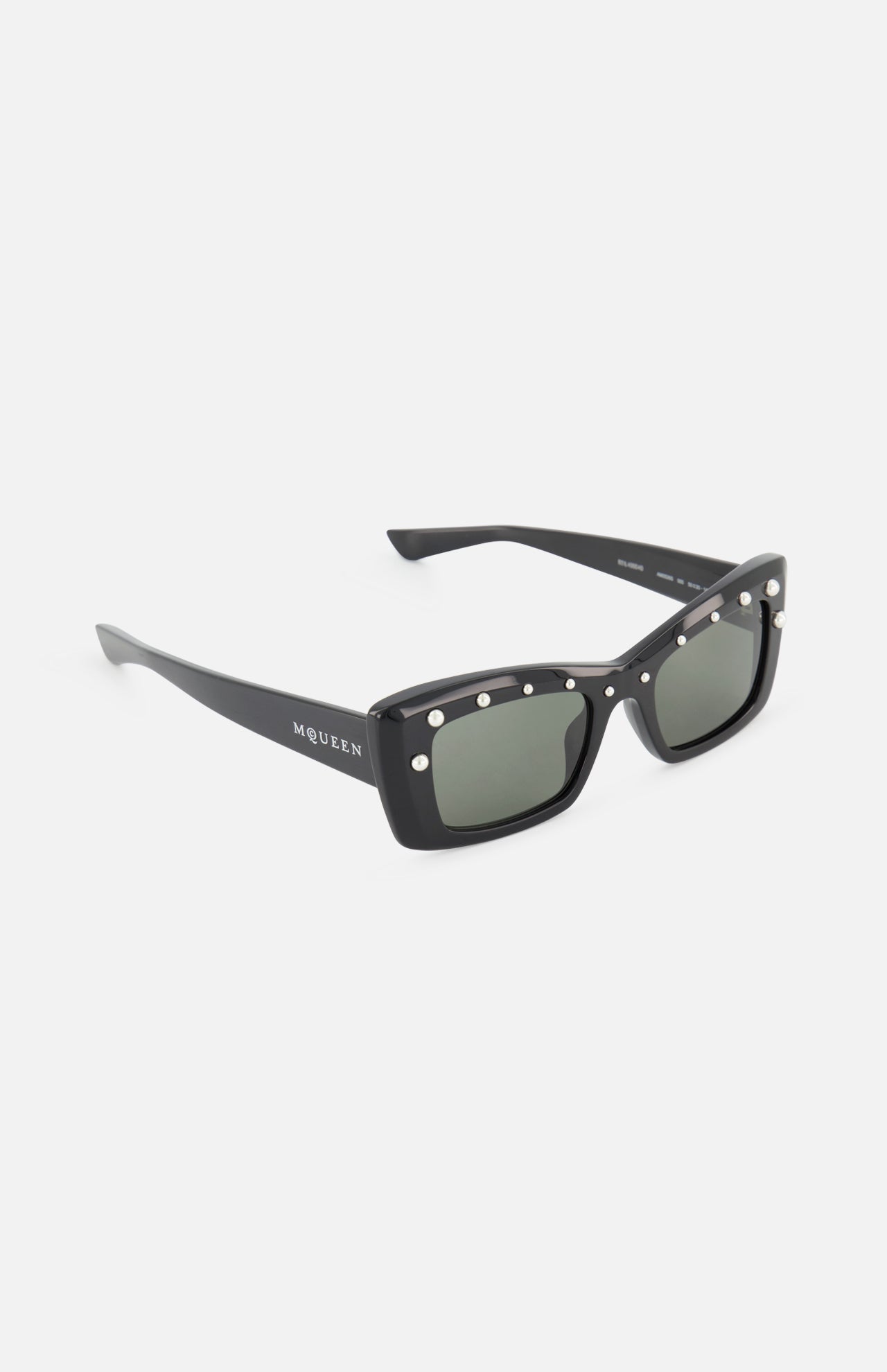 The Alexander McQueen Cat Eye Black Sunglasses by ALEXANDER MCQUEEN feature a sleek rectangular cat eye frame, metallic side studs, dark lenses, and branded temples, shown on a white background.