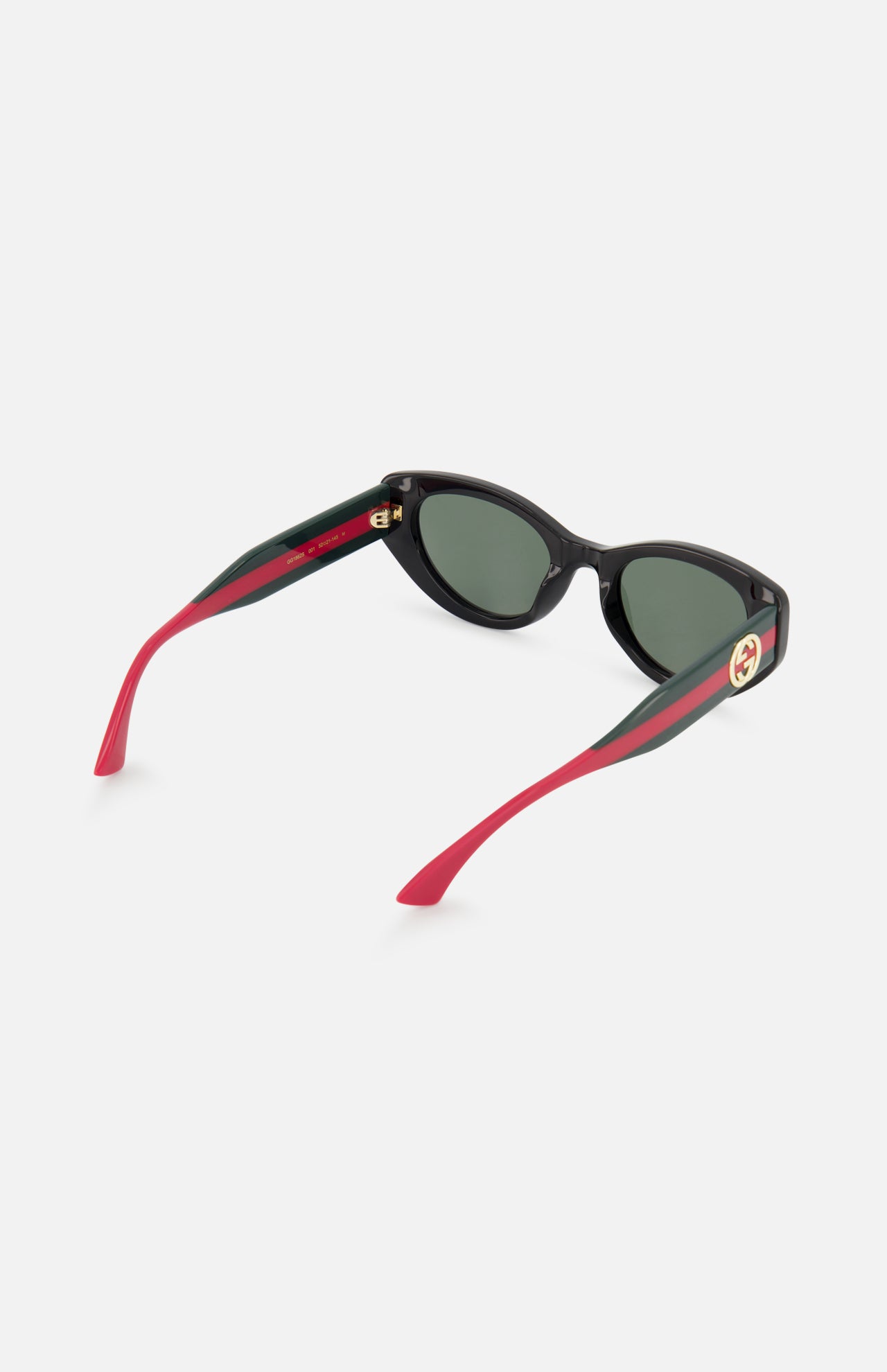 The Gucci Cat Eye Black Sunglasses by GUCCI feature dark tinted lenses, red-green striped arms, and a solid red interior with a gold circular logo. These designer frames stand out against a crisp white background.