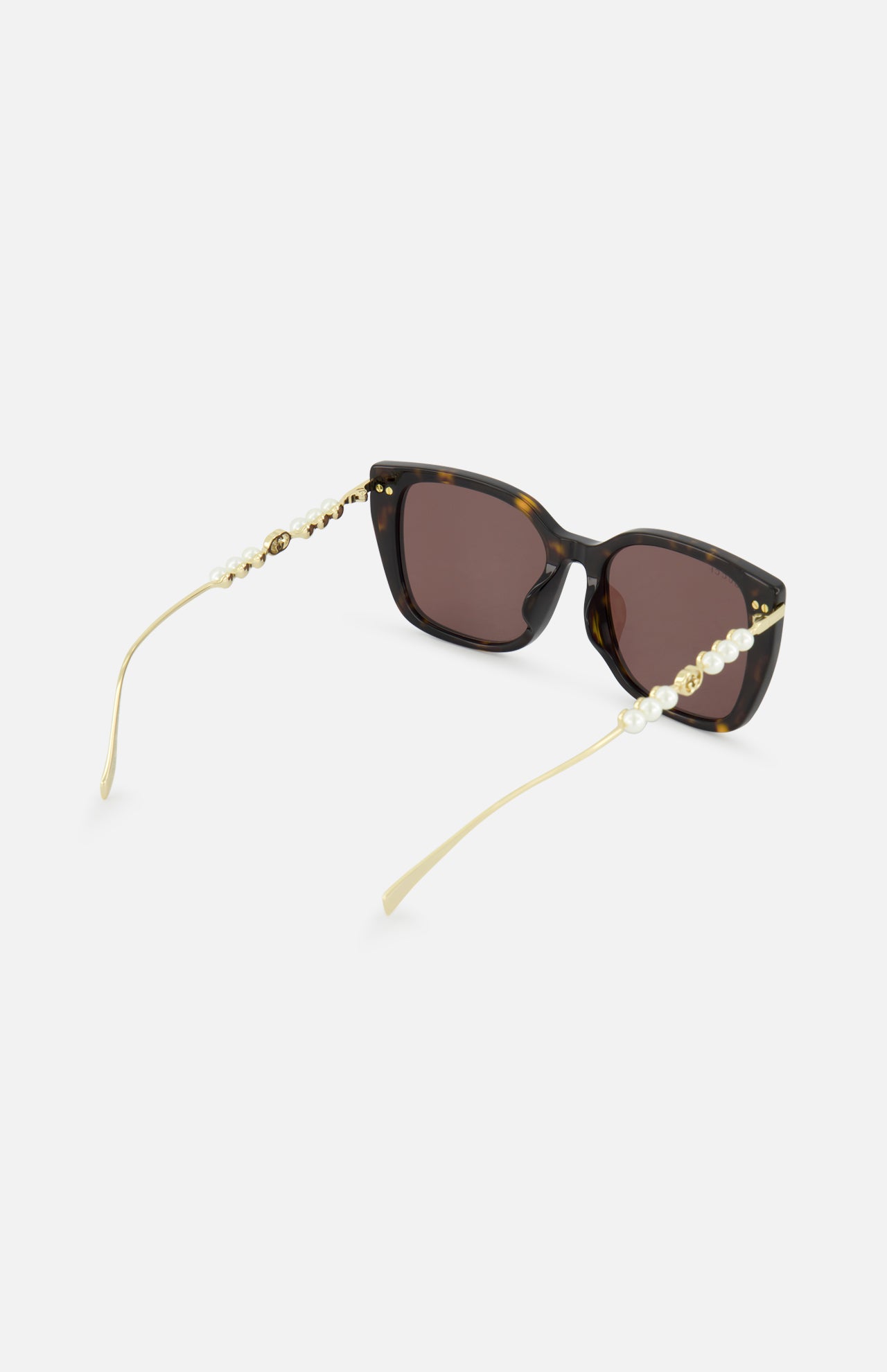Gucci Brown Tortoiseshell Sunglasses by GUCCI feature a subtle butterfly frame, dark lenses, gold arms with pearl accents, and are shown on a white background.