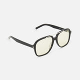 The YSL Aviator Black Sunglasses by YVES SAINT LAURENT feature oversized black frames and slightly yellow-tinted lenses with a retro-inspired design, shown at an angle on a white background.