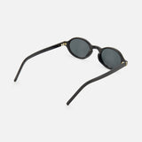 YSL Round Black Sunglasses by YVES SAINT LAURENT, featuring a minimalist oval design, dark lenses, and gently curved arms, displayed angled from the side and back on a white background.