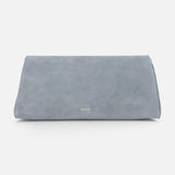 The Audrey Art Deco Suede Clutch by KHAITE is a minimalist, rectangular pale blue bag with Art Deco-inspired hardware and small gold lettering near the bottom center, shown on a plain white background.