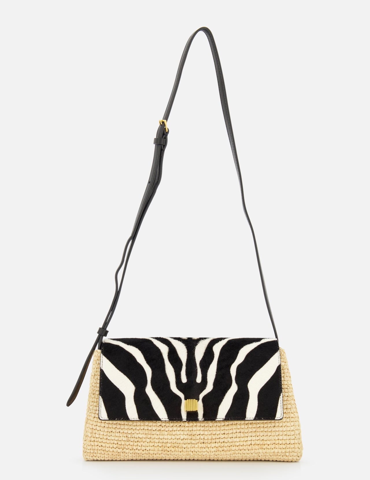 The KHAITE Audrey Raffia Crossbody Bag features a woven straw base, black adjustable strap, and a striking black and white animal print flap for standout style.