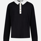The Faithful Vintage Rugby Top by KHAITE is a unisex, long-sleeve black silk polo with a white collar and five-button placket, crafted from organic Japanese silk and shown on a plain white background.
