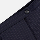 Close-up of KHAITE's Jude Striped Wool-blend Pant—dark trousers with a waistband, black button, and subtle vertical stripes, perfect for a minimalist wardrobe.