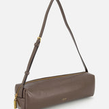 The KHAITE Kye Patent Leather Shoulder Bag features brown patent leather, a gold zipper, and an adjustable strap, shown against a white background.