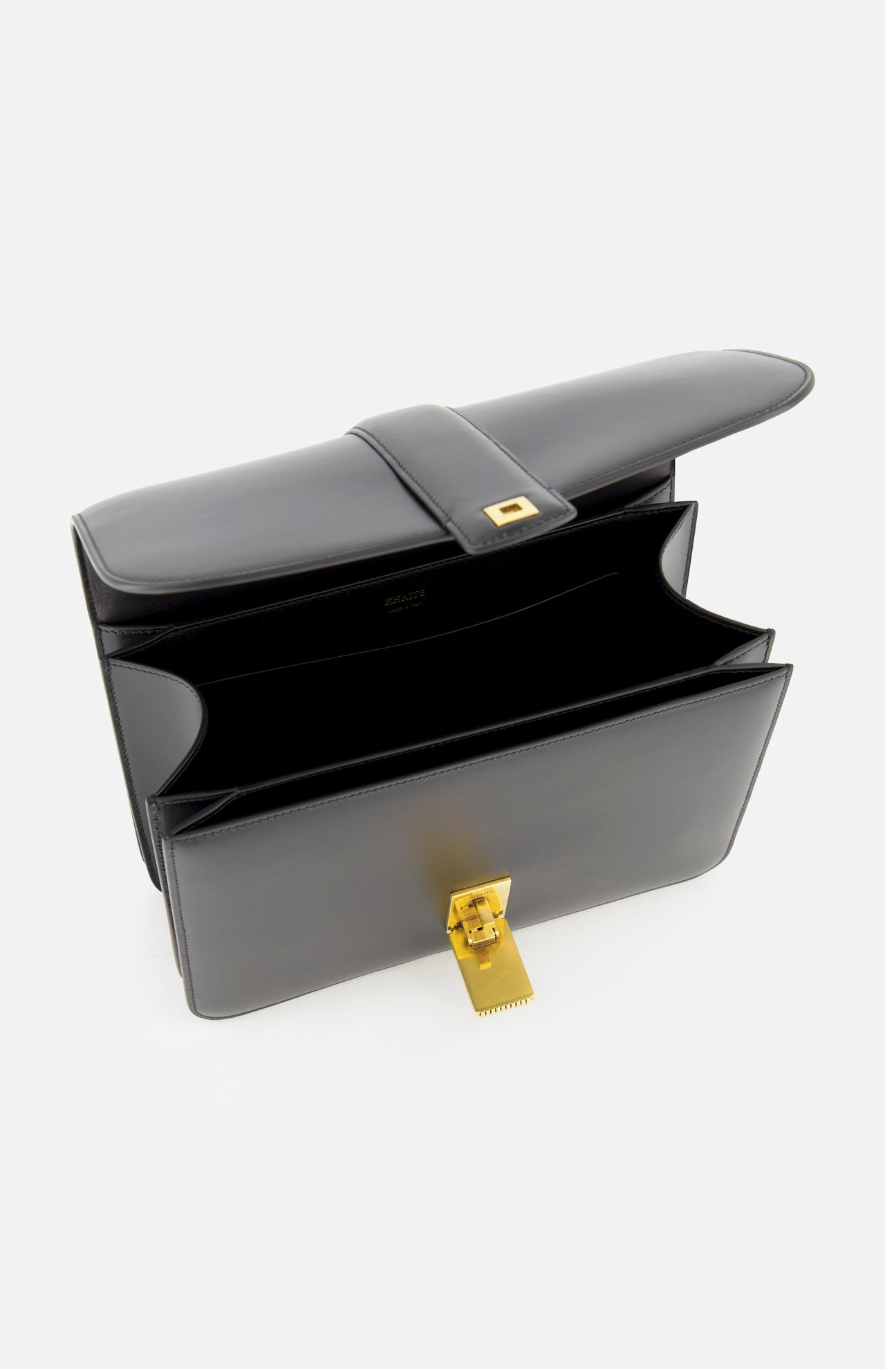 The KHAITE Blake Leather Crossbody Bag, crafted in black leather with Italian expertise and a gold clasp, is open to reveal its spacious interior and sleek design against a white background.