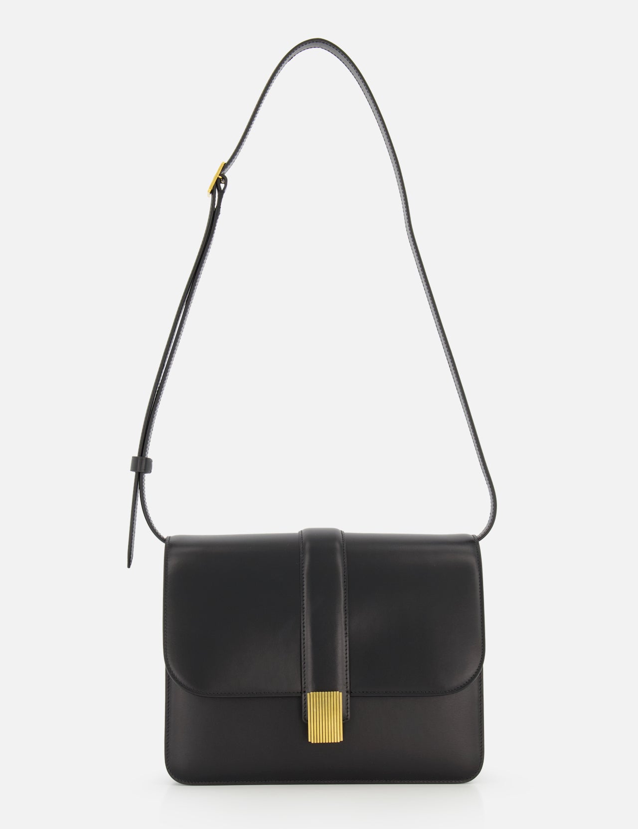 The KHAITE Blake Leather Crossbody Bag highlights Italian craftsmanship with sleek black leather, a gold rectangular flap clasp, and a single adjustable strap. Its minimalist, elegant design stands out against a plain white background.